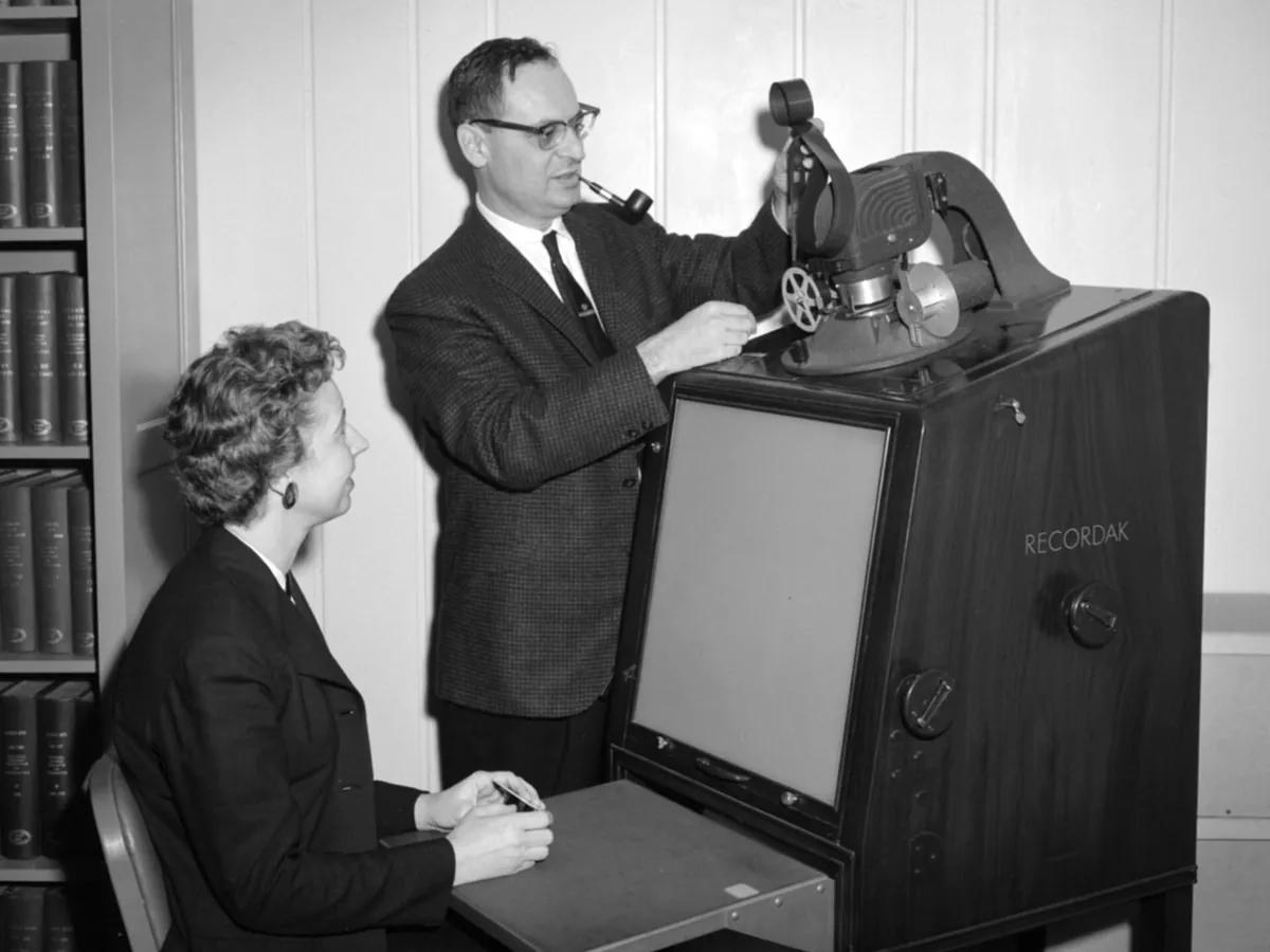 A library staff member operating a microfilm reader at a research centre in 1961.