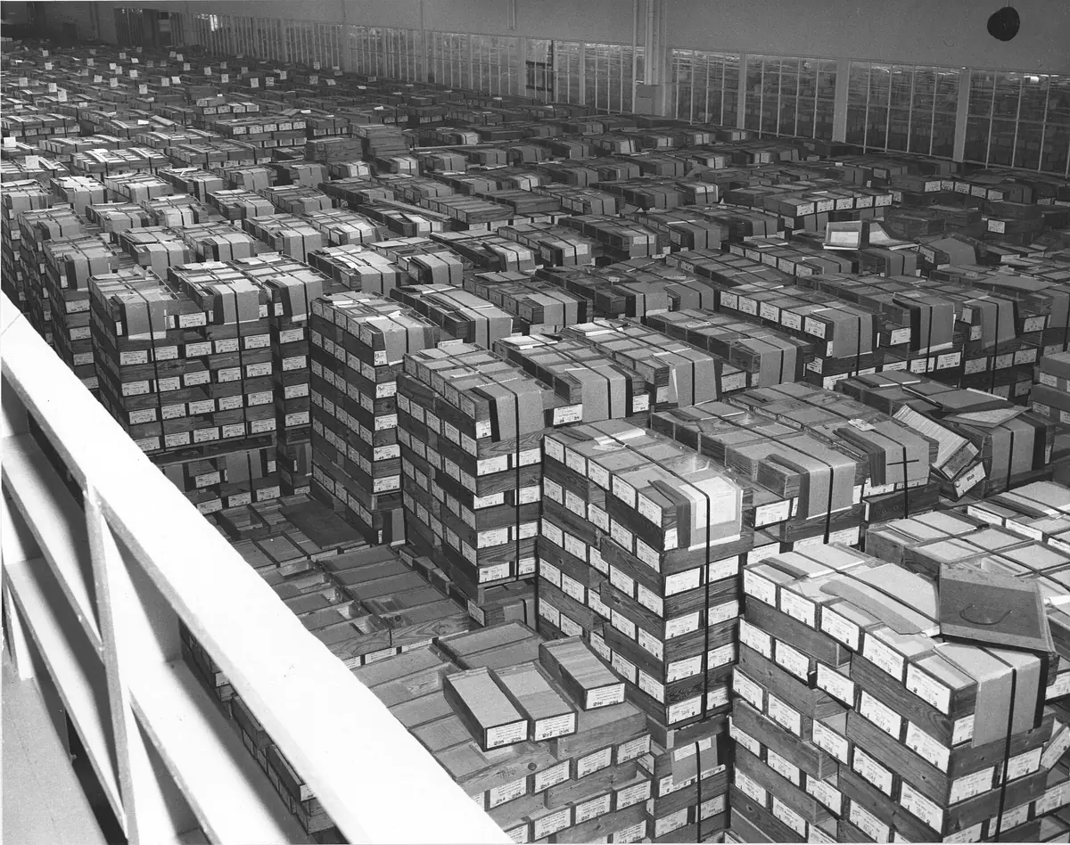 Aisles of shelving filled with boxes of IBM punched cards in a records store.